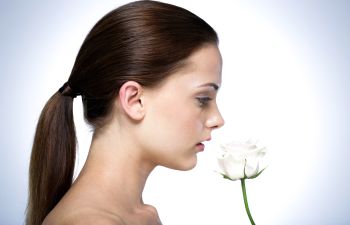 A woman with long dark hair dressed up in a ponytail.