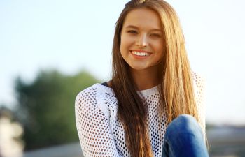 A young happy woman with straight long hair.