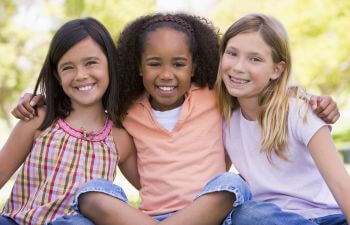 Three little girl friends with long hair.