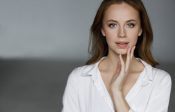 blonde haired woman in a white shirt and soft make up