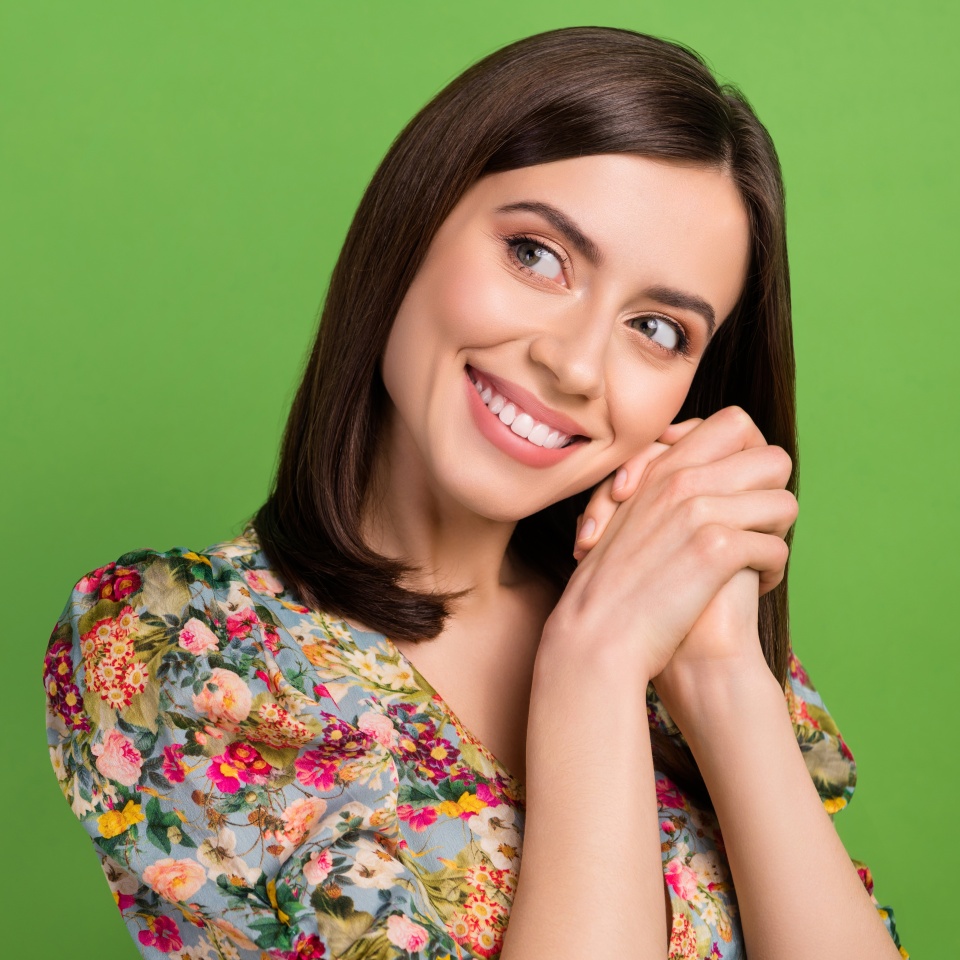 Photo of modest young attractive lady folded hands together look dreams empty space expect boyfriend gift isolated on green background