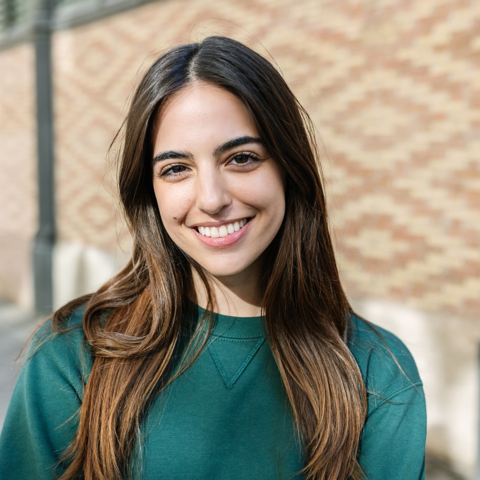 Portrait of cheerful young caucasian girl smiling at camera over city urban background