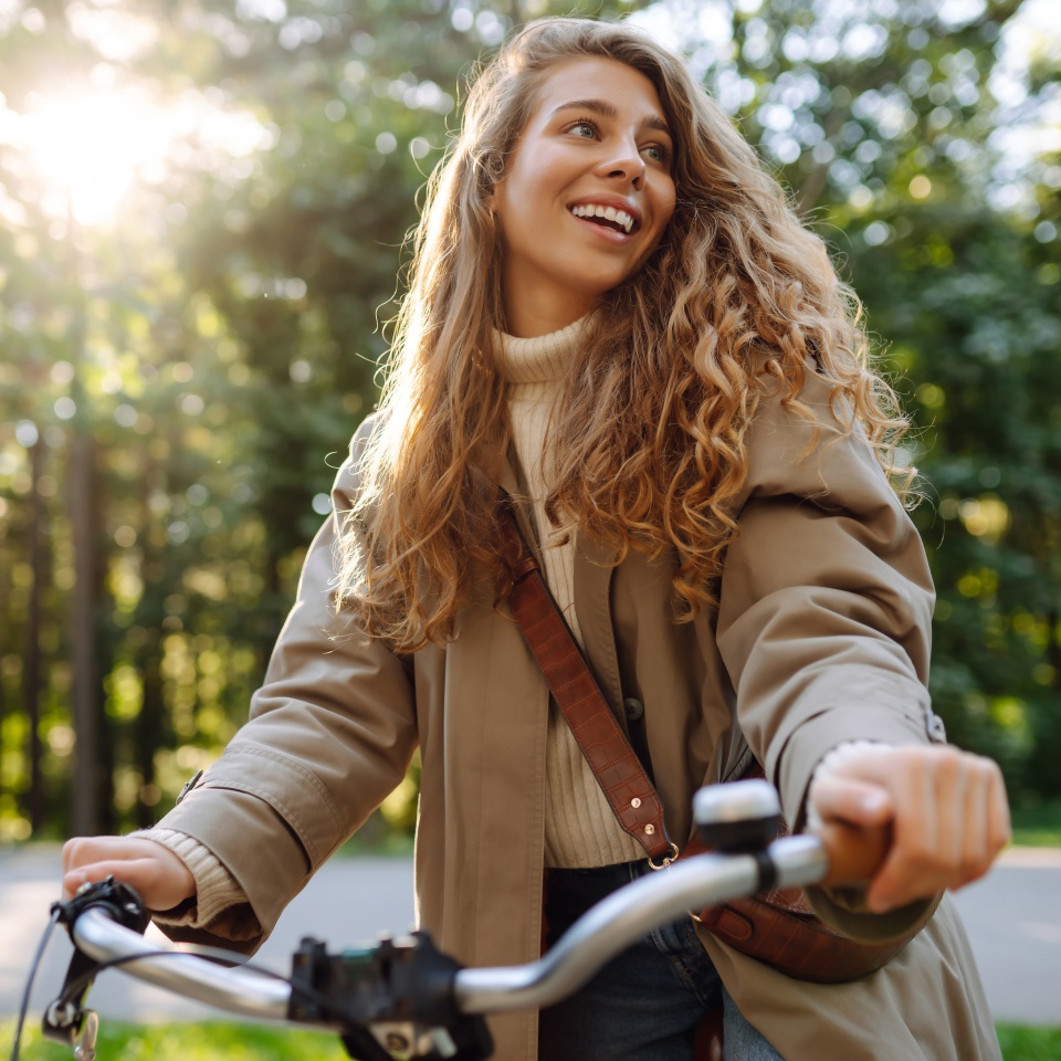 Happy woman tourist woman using bicycle in the park. Active lifestyle. The concept of nature.