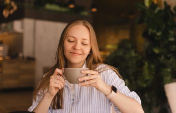 Portrait of gorgeous blonde smiling lady smelling