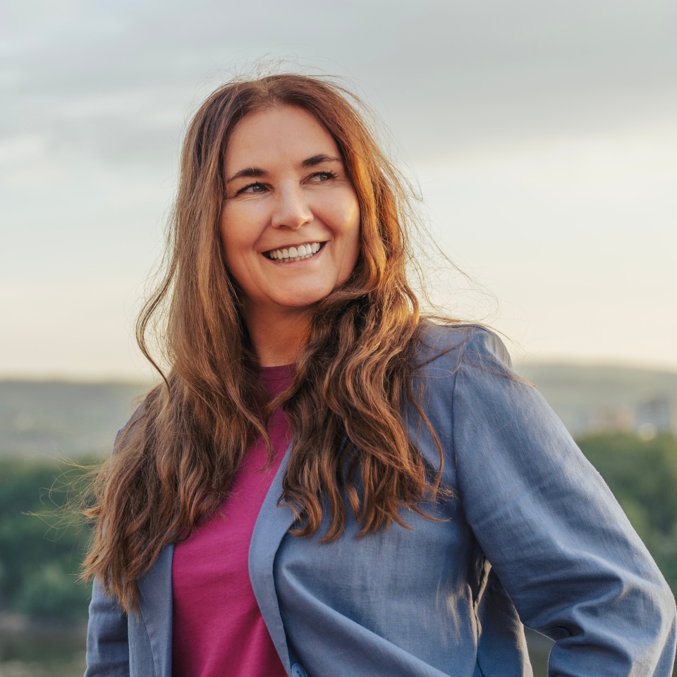Portrait of attractive middle aged woman with long hair outdoors at sunset