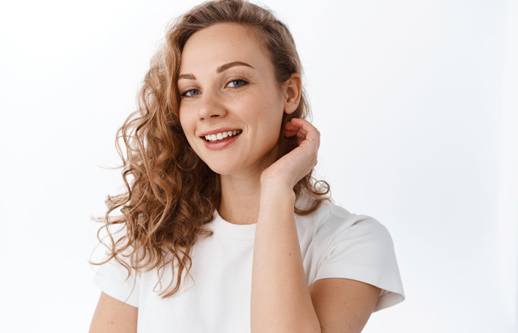 A person with curly hair smiles