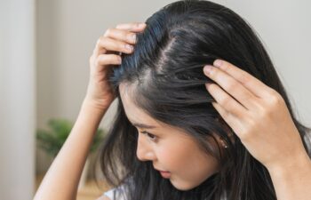 Damaged hair symptom, problem hair fall asian young woman, girl worry about balding, looking at scalp in mirror, hand in break into front hair loss, thin problem. Health care treatment for beauty.